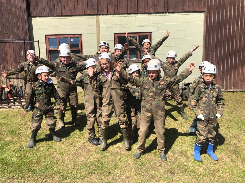 Group of kids kitted out in protective overalls and helmets