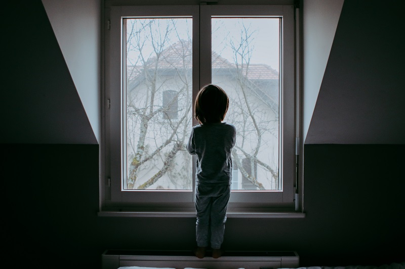 Child-looking-out-rainy-window