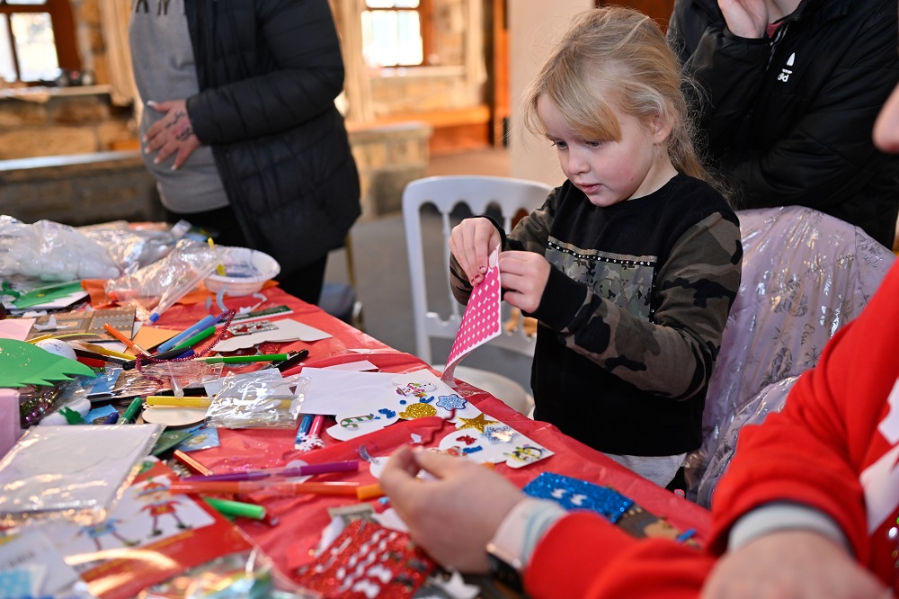 Girl doing Christmas crafts at Lineham Farm