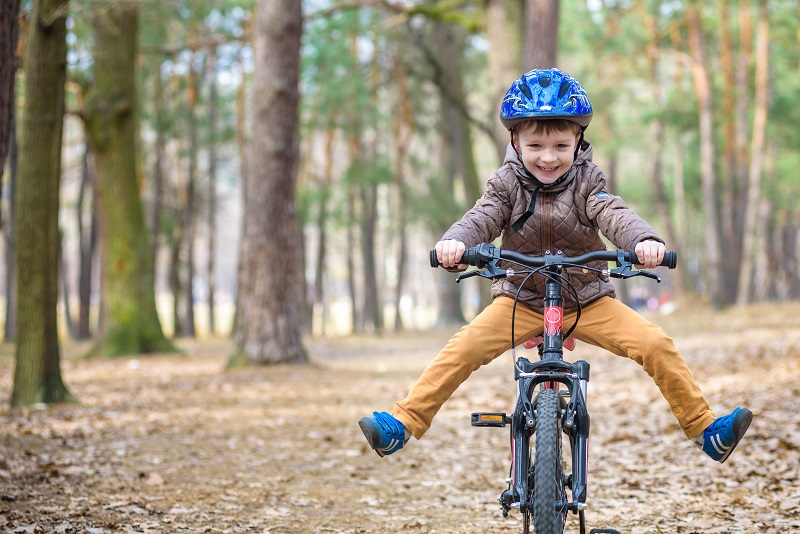 Child riding a bike in the woods