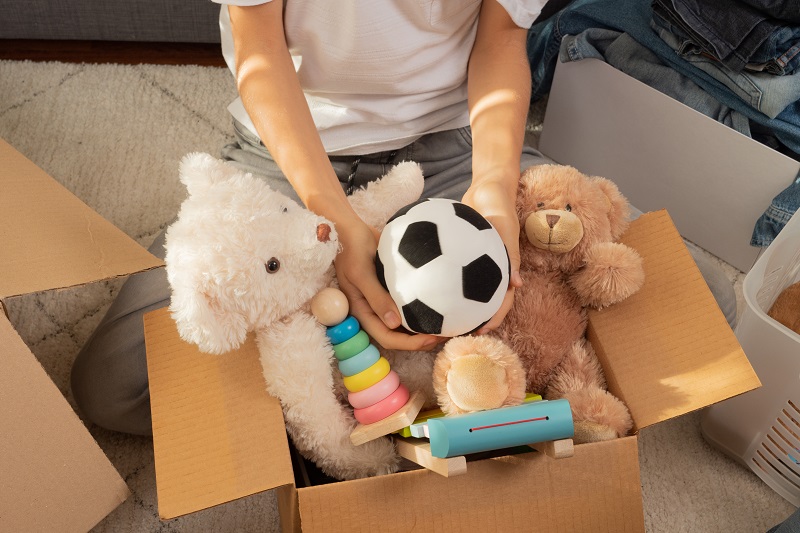 Person organising toys to donate to charity 